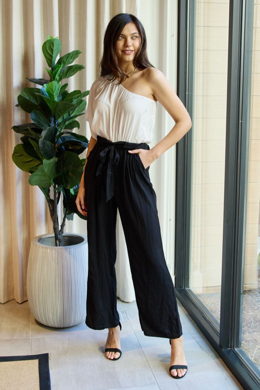 White and black one-shoulder jumpsuit from Trendsi's Dress Day Marvelous in Manhattan collection, styled for elegant occasions.