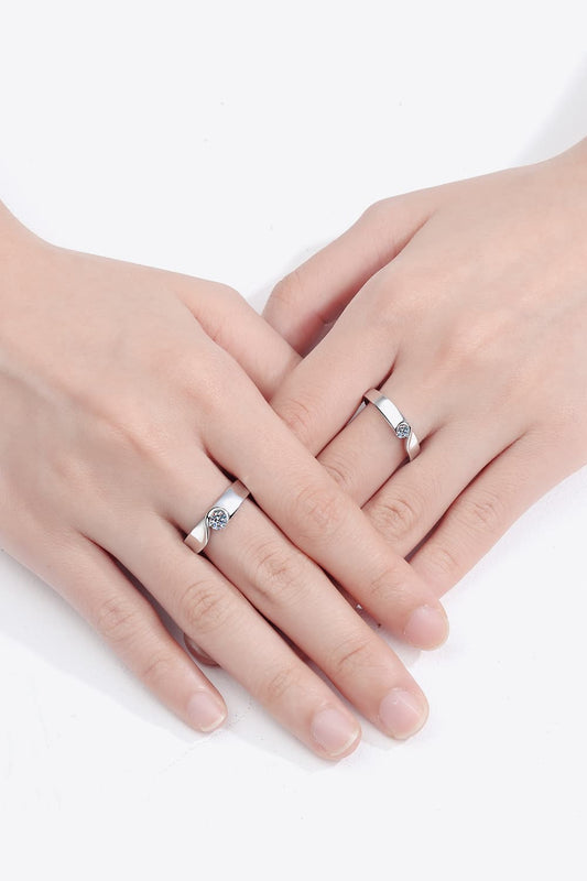 Rhodium-plated moissanite ring with sparkling gemstones, elegant jewelry piece showcasing a shiny silver finish.