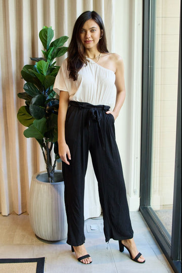 White and black one-shoulder jumpsuit from Trendsi's Dress Day Marvelous in Manhattan collection, stylish and elegant for any occasion.
