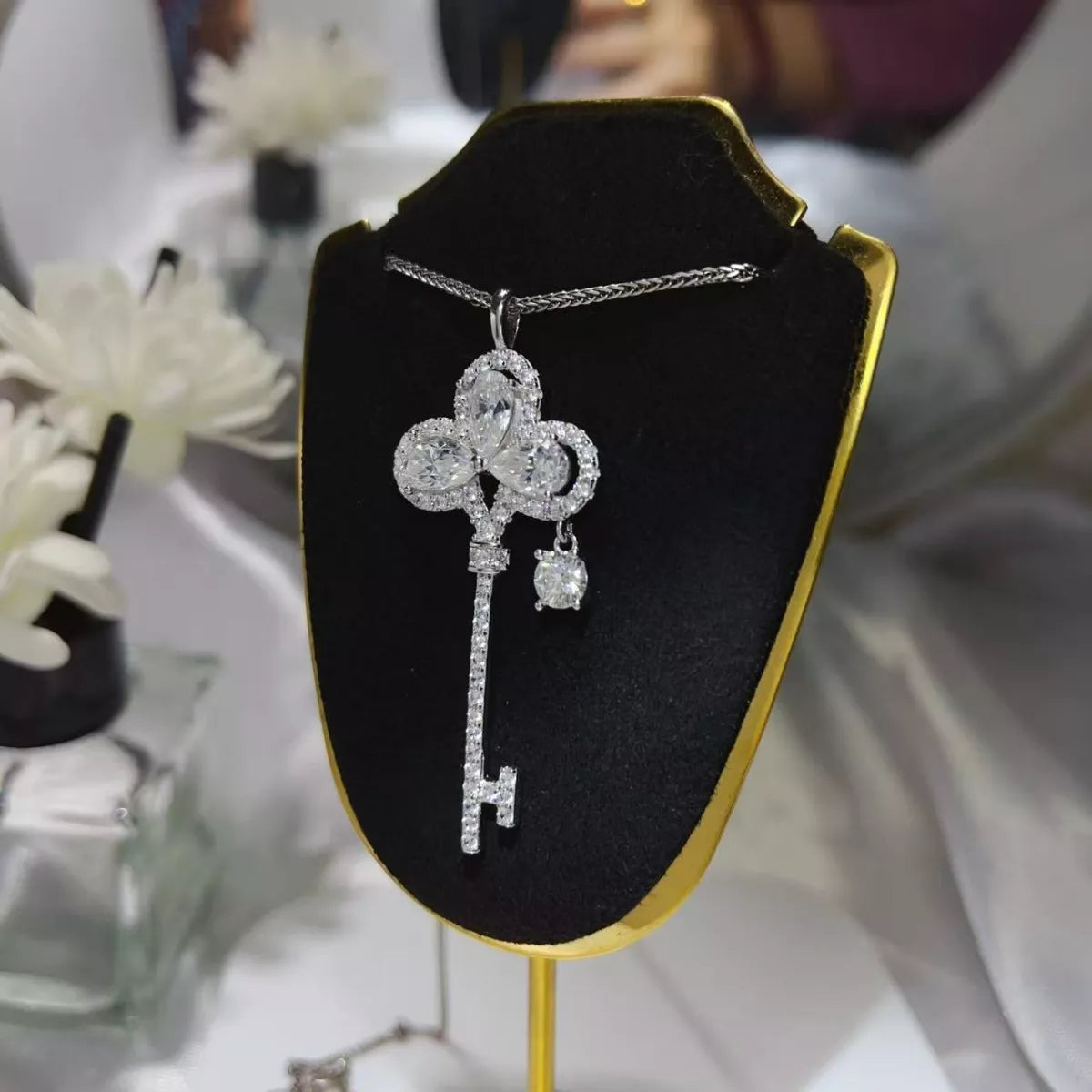 Sterling silver key necklace with 3.5 carat moissanite gemstone, featuring a delicate design and adjustable chain.