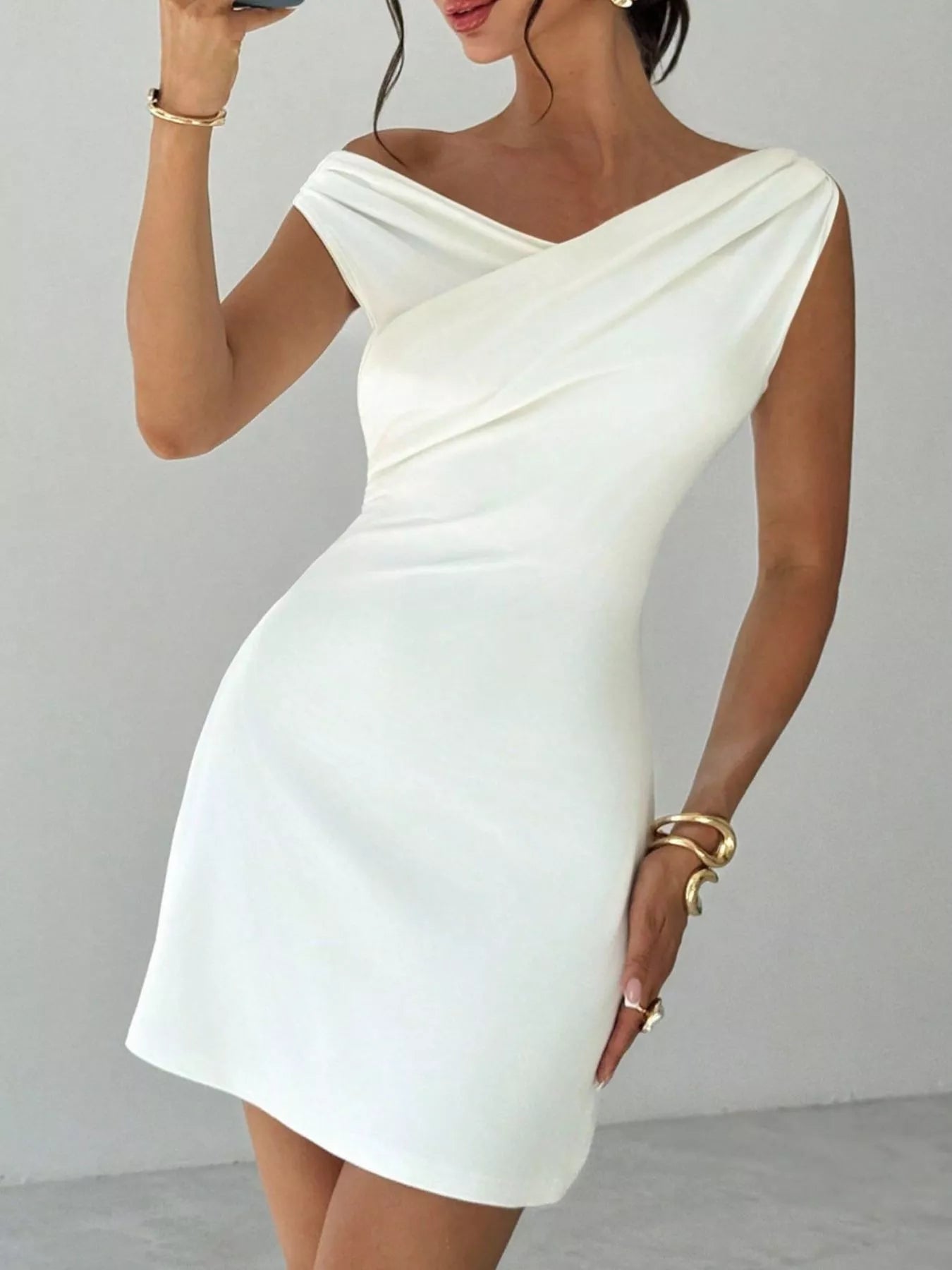 White elegant off-shoulder draped mini dress by Trendsi, featuring a stylish design and flattering fit for fashionable occasions.